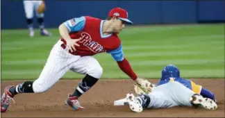  ?? TOM E. PUSKAR — THE ASSOCIATED PRESS ?? Phillies’ shortstop Scott Kingery, left, tags out Amed Rosario on a stolen base attempt during the Little League Classic at Bowman Field in Williamspo­rt Sunday.