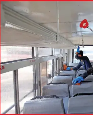  ??  ?? Workers disinfect the interiors of a passenger bus in Ahmedabad, Gujarat