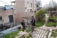 ?? Mahmoud Illean/Associated Press ?? Israeli officers patrol at the sealed-off home of a Palestinia­n gunman who killed seven people outside a synagogue Friday.