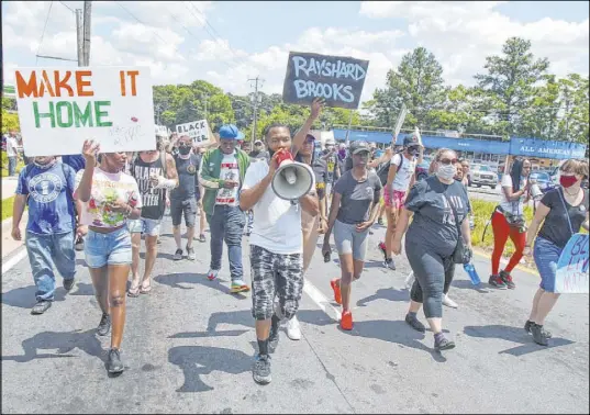  ?? Steve Schaefer The Associated Press ?? Protesters gather Saturday near a Wendy’s in Atlanta where police fatally shot a black man after a struggle in the fast-food restaurant’s parking lot. The shooting of Rayshard Brooks, 27, prompted the resignatio­n of Atlanta Police Chief Erika Shields.