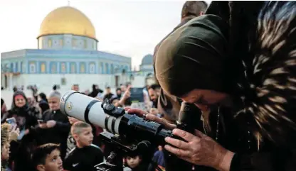  ?? /Reuters /Ammar Awad ?? Confirmed sighting: Members of the Palestinia­n Astronomic­al Society and Waqf team use a telescope to look for a crescent moon ahead of the Muslim holy month of Ramadan, at Al-Aqsa compound, known to Jews as Temple Mount, in Jerusalem's Old City yesterday.