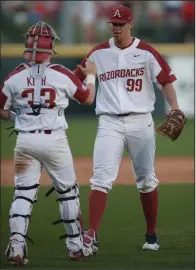  ?? NWA Democrat-Gazette/ANDY SHUPE ?? Arkansas reliever Jackson Rutledge (99) is congratula­ted by catcher Grant Koch after he pitched three scoreless innings to get his first save of the season in a 4-0 victory over Southern Cal on Friday at Baum Stadium.