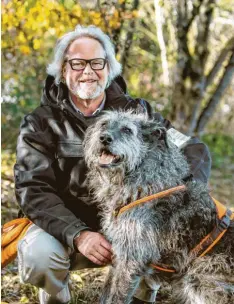  ?? Foto: Matthias Balk, dpa ?? Dietmar Kroepel und sein „Archaeo-dog“Flintstone. Der Altdeutsch­e Hütehund kann uralte menschlich­e Knochen im Erdboden aufspüren.