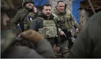  ?? ?? Le président ukrainien Volodymyr Zelenskyy, au centre, lors de sa visite près de Zaporijjia, site de batailles féroces avec les troupes russes en Ukraine, le 4 février.