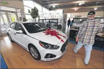  ?? DAVID ZALUBOWSKI /ASSOCIATED PRESS ?? A buyer walks past a 2018 Sonata sitting Friday on the showroom floor of a Hyundai dealership in Littleton, Colo. Hyundai is training its dealers to make the car-buying experience easier for consumers.