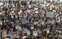  ?? Reuters ?? Demonstrat­ors hold pictures of their missing and killed relatives during a 2008 protest in Najaf, Iraq