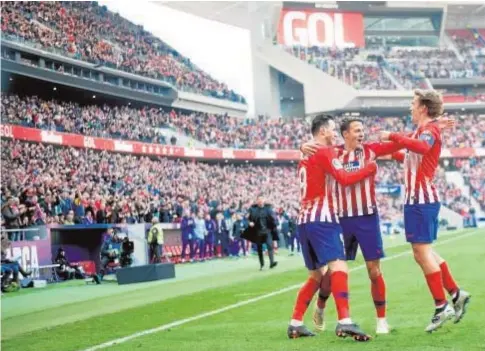  ?? AFP/CURTO DE LA TORRE ?? Santiago Arias y Griezmann acuden a felicitar a Kalinic por su gol ante el Alavés