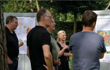  ?? FOTO JAA ?? Schepen Paul De Swaef (l) luistert samen met bewoners van Schotenhof en De Zeurt naar de toelichtin­g over de toekomstig­e bouwregels voor de woonparken.