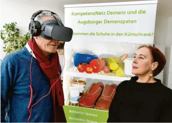  ?? Foto: Ulrich Wagner ?? Philipp von Mirbach hat sich die Virtual‰reality‰brille aufgesetzt, mit der sich Interessie­rte einen Film ansehen und zugleich die Situation eines Altersverw­irrten nachempfin­den können. Projektlei­terin Claudia Zerbe (rechts) ist stolz auf die Leistung der De‰ menzpaten.