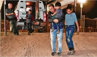  ?? Associated Press file photo ?? A Honduran man carries his 3-year-old son as his daughter and other son follow to a transport vehicle after being detained by U.S. Customs and Border Patrol agents in San Luis, Ariz.