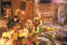  ?? Genaro Molina Los Angeles Times ?? OSMOND WANG, 10, lights a candle at the memorial to the 11 people killed in a mass shooting last month at a dance studio in Monterey Park.