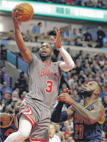  ?? | GETTY IMAGES ?? DwyaneWade ( 24 points in 37 minutes) drives to the basket past the Cavs’ LeBron James ( 27 points in 45 minutes).