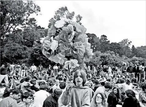  ?? TED STRESHINSK­Y PHOTOGRAPH­IC ARC/CORBIS ?? A boy carries paper flowers on a pole at a 1967 summer solstice celebratio­n at Golden Gate Park in San Francisco.