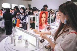  ?? PROVIDED TO CHINA DAILY ?? Visitors gather at the booth of Chinese beauty brand Huaxizi, or Florasis, during a beauty industry expo in Shanghai in May 2023.