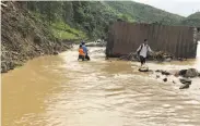  ?? Huu Quyet / Associated Press ?? Residents wade through flood water in northern province of Son La, after a tropical depression.