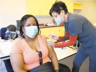  ?? PAUL W GILLESPIE/CAPITAL GAZETTE PHOTOS ?? Cynthia Francis gets her shot from registered nurse MJ Eckert on Thursday, as the Anne Arundel County Department of Health began administer­ing the Moderna COVID-19 vaccine at the Lula G Scott Community Center in Shady Side.