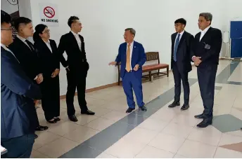  ?? ?? Dr Sim (third right) speaks to Shankar (right) and other members of his legal team at the court lobby.