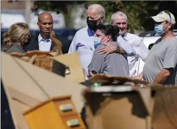  ?? EVAN VUCCI — THE ASSOCIATED PRESS ?? President Joe Biden hugs a person Tuesday as he tours a neighborho­od in Manville, N.J., impacted by Hurricane Ida. Sen. Cory Booker, D-N.J., second from left, and New Jersey Gov. Phil Murphy, second from right, look on.