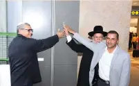  ?? (Morag Bitan) ?? RANI ZIM, Office Depot owner, Elad Chief Rabbi Mordehai Malka and deputy director-general of Israel Airports Authority Yoram Shapira inaugurate a new store with a mezuzah.