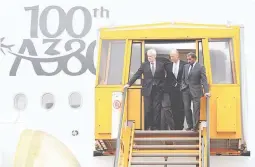  ??  ?? Sheikh Ahmed bin Saeed Al Maktoum, Emirates' chairman and CEO (R), Tom Enders, CEO of Airbus (L), and Tim Clark President of Emirates Airlines, descend the steps of Airbus A380 during a delivery ceremony of Emirates' 100th Airbus A380 at the German...