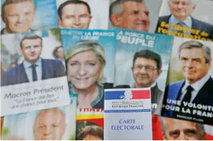  ?? Reuters ?? A photo illustrati­on shows a French voter card in front of pictures of the candidates for the French presidenti­al election in Paris on Saturday. —