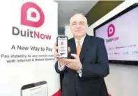  ?? BERNAMAPIX ?? PayNet group CEO Peter Schiesser displaying the ‘DuitNow’ app.