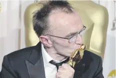  ?? ?? Slumdog Millionair­e director Danny Boyle kisses his Oscar, one of eight the hit film scooped on this day in 2009