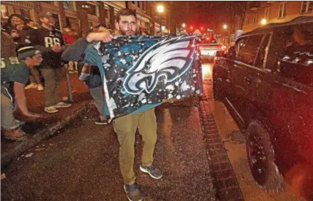  ?? PETE BANNAN – DIGITAL FIRST MEDIA ?? Fans celebrate outside the Side Bar in West Chester Sunday night after the Eagles won their first Super Bowl, defeating the defending champions, the New England Patriots.