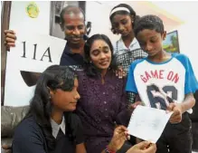  ??  ?? Yallene (seated left) showing her SPM result slip to Pandiyan, Pathma, Kanimolly and Kaaviyaan at their family home.