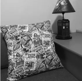  ??  ?? Heather also helped with fun touches like these custom Dr. Who throw pillows for the couch.