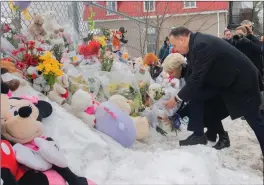  ?? The Canadian Press ?? Quebec Premier Francois Legault and wife Isabelle Brais lay flowers as they visit the site of a daycare centre in Laval, Que, Thursday, where a city bus crashed into the building killing two children.