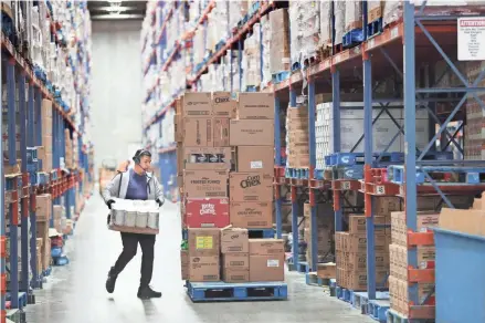  ?? MICHAEL SEARS/MILWAUKEE JOURNAL SENTINEL ?? A warehouse staff member picks items off shelves to be loaded on a truck and shipped to a store requesting the items at the Roundy’s Supermarke­ts distributi­on center in Oconomowoc on April 1.