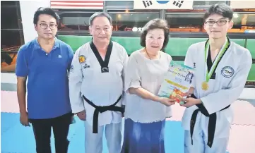  ??  ?? Lau (third left) presents incentive to Si Xiang. Looking on from left are RTC treasurer Albert Wong and Tang.