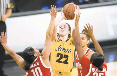  ?? CHARLIE NEIBERGALL/AP FILE ?? Iowa guard Caitlin Clark, center, leads the nation in scoring going into the NCAA women’s basketball tournament.