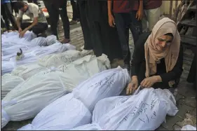  ?? SAMAR ABU ELOUF — NEW YORK TIMES FILE ?? A woman mourns the loss of family members killed in Israeli airstrikes in Deir al Balah in the central Gaza Strip on Oct. 23.