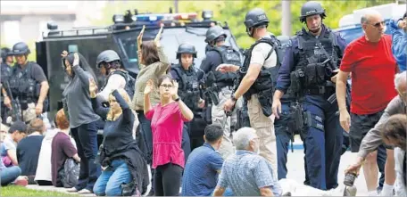  ?? Jay L. Clendenin Los Angeles Times ?? POLICE OFFICERS check students after last week’s fatal shooting of a professor on the UCLA campus. A task force will look at several issues, including how students and faculty received emergency notificati­ons and complaints about classroom security and...