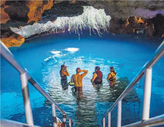  ?? PATRICK CONNOLLY/ORLANDO SENTINEL PHOTOS ?? Visitors congregate on the entrance platform at Devil’s Den Spring in Williston in 2018.