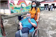  ?? ?? Helleda wheels her mother out of SK Pujut Corner polling centre after casting her vote.