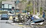  ?? THE ASSOCIATED PRESS ?? Officials with the National Transporta­tion Safety Board and FAA investigat­e the cause of the crash of a Cessna Citation I on Saturday in Kennesaw, Ga. The small plane crashed into a suburban Atlanta neighborho­od Friday evening, killing the pilot and...