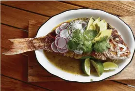  ?? Photos by Karen Warren / Staff photograph­er ?? Crispy whole red snapper with tomatillo salsa, flour tortillas, black beans and white rice at Superica