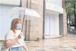  ?? ?? A woman walks past the closed H&M flagship store in Shanghai yesterday.