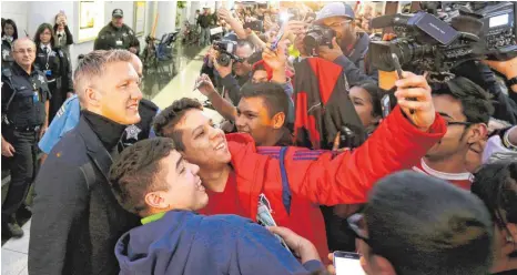  ?? FOTO: DPA ?? Einmal ein Selfie mit dem Weltmeiste­r: Für diese beiden jungen Männer ist am Flughafen von Chicago ein Lebenstrau­m in Erfüllung gegangen, für Bastian Schweinste­iger offenbar auch. Er liebe Amerika, sagte der 32-Jährige.