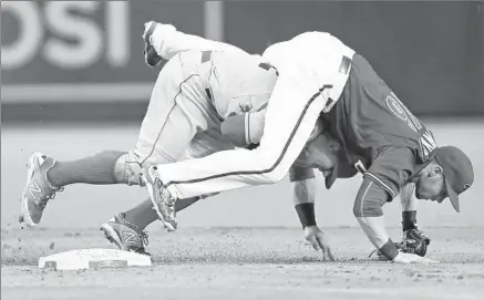  ?? Rob Schumacher Associated Press ?? SECOND BASEMAN
Chris Owings lands on Johnny Giavotella of the Angels as he completes a double play in the fifth inning.