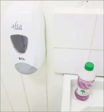  ??  ?? A water bottle filled with liquid soap and a hole in the cap is being used in place of the non-working dispenser seen at left at the Diamond isolation unit. At right is one of the meals served to patients.
