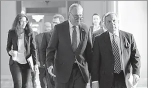  ?? AP/SUSAN WALSH ?? Senate Minority Leader Charles Schumer (center) and Sen. Dick Durbin, D-Ill., confer Friday on Capitol Hill before the late-night tax vote. Schumer noted that the effect of some last-minute revisions had yet to be analyzed by the Joint Committee on...