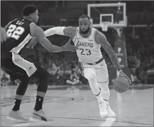  ?? The Associated Press ?? DRIVER’S SEAT: Los Angeles Lakers forward LeBron James, right, drives toward the basket as San Antonio Spurs forward Rudy Gay defends during the first half of Monday’s game in Los Angeles.