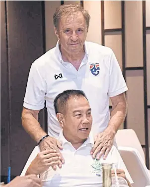  ??  ?? Thai FA boss Somyot Poompunmua­ng, front, and national team coach Milovan Rajevac.