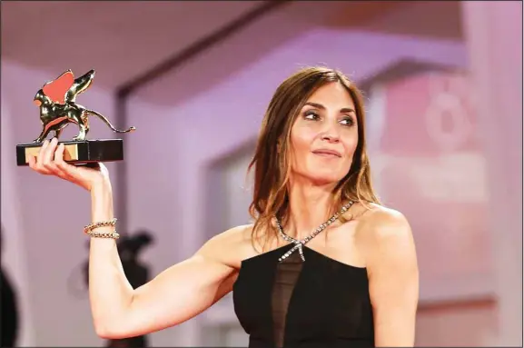  ??  ?? Audrey Diwan holds the Golden Lion award for ‘Happening’ after the closing ceremony of the 78th edition of the Venice Film Festival in Venice, Italy, Saturday, Sept. 11. (AP)