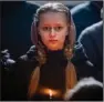  ?? (AP/Emilio Morenatti) ?? A relative holds a candle Wednesday during a funeral near Kyiv, Ukraine, for Roman Shevchenko, 40, a civilian who volunteere­d to fight and was killed Feb. 9.