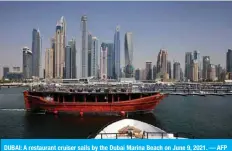  ??  ?? DUBAI: A restaurant cruiser sails by the Dubai Marina Beach on June 9, 2021. — AFP